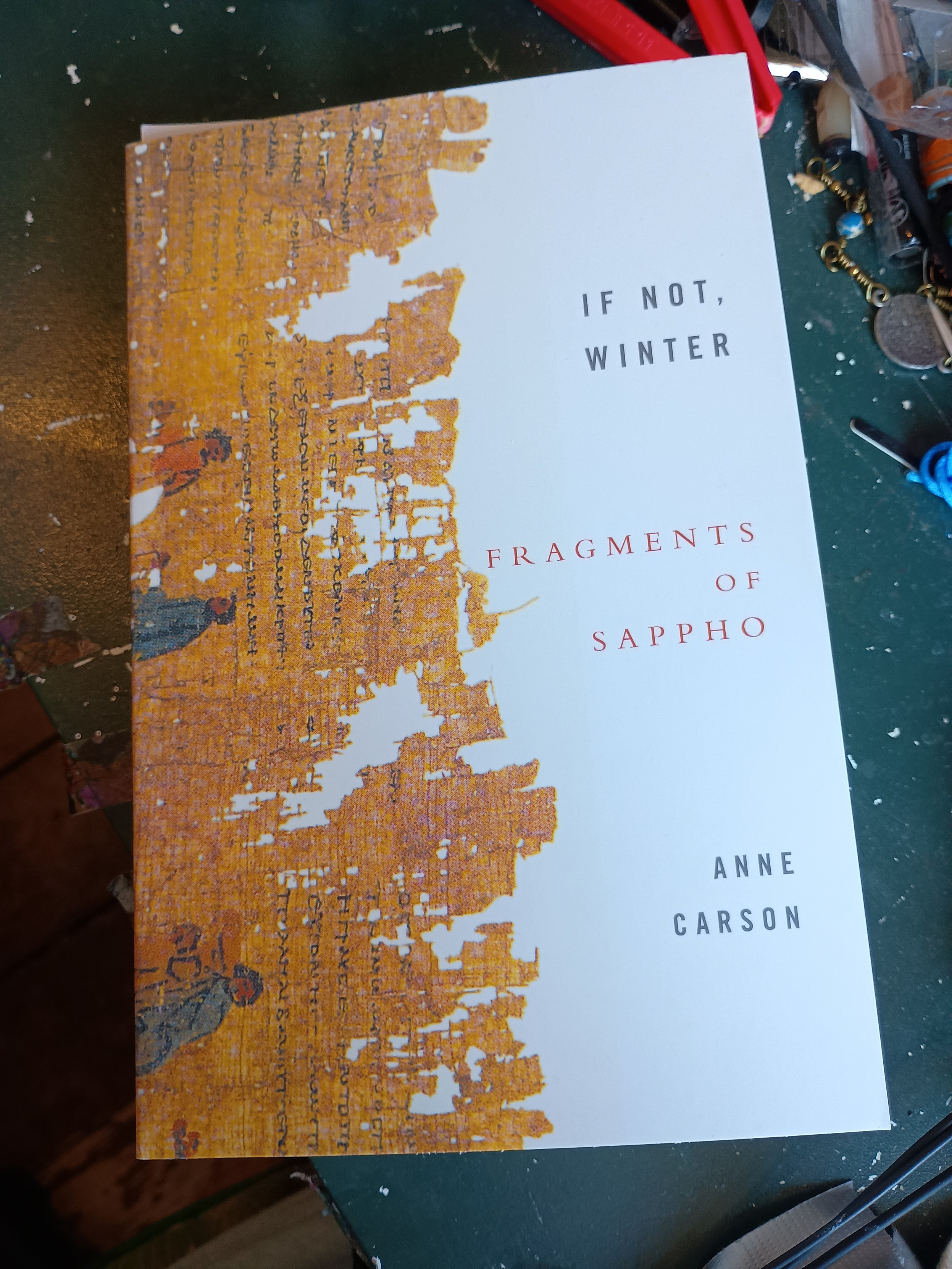Cover of "If Not, Winter" (Fragments of Sappho) by Anne Carson.  Left hand side of the cover is a picture of one of the partially destroyed original texts, right hand side is plain white and includes the title and author.